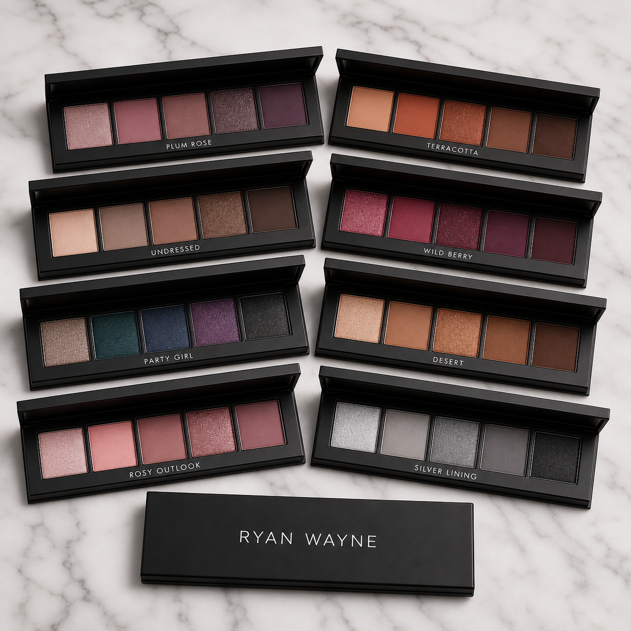 Ryan Wayne Pentamerous Eyeshadow eight five-pan palettes on white marble