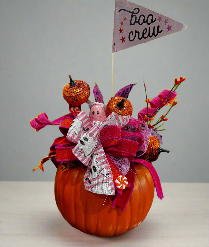 Decorative Halloween wreath with pumpkins and festive ribbons on a dark background