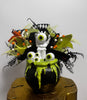 Decorative Halloween-themed topiary with green and black leaves on a white background