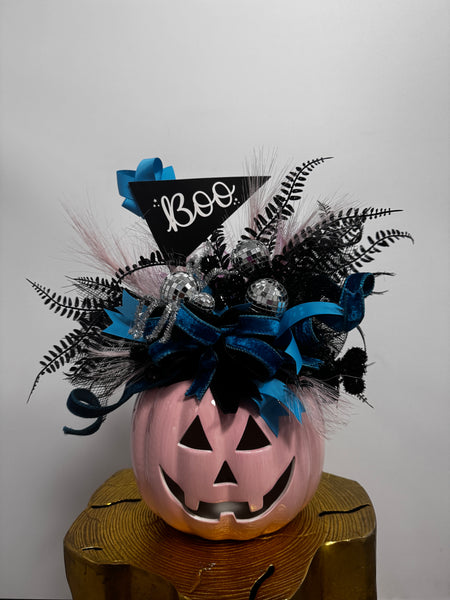 Halloween-themed decorative item with a jack-o'-lantern face and decorative elements on a white background