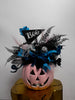 Halloween-themed decorative item with a jack-o'-lantern face and decorative elements on a white background