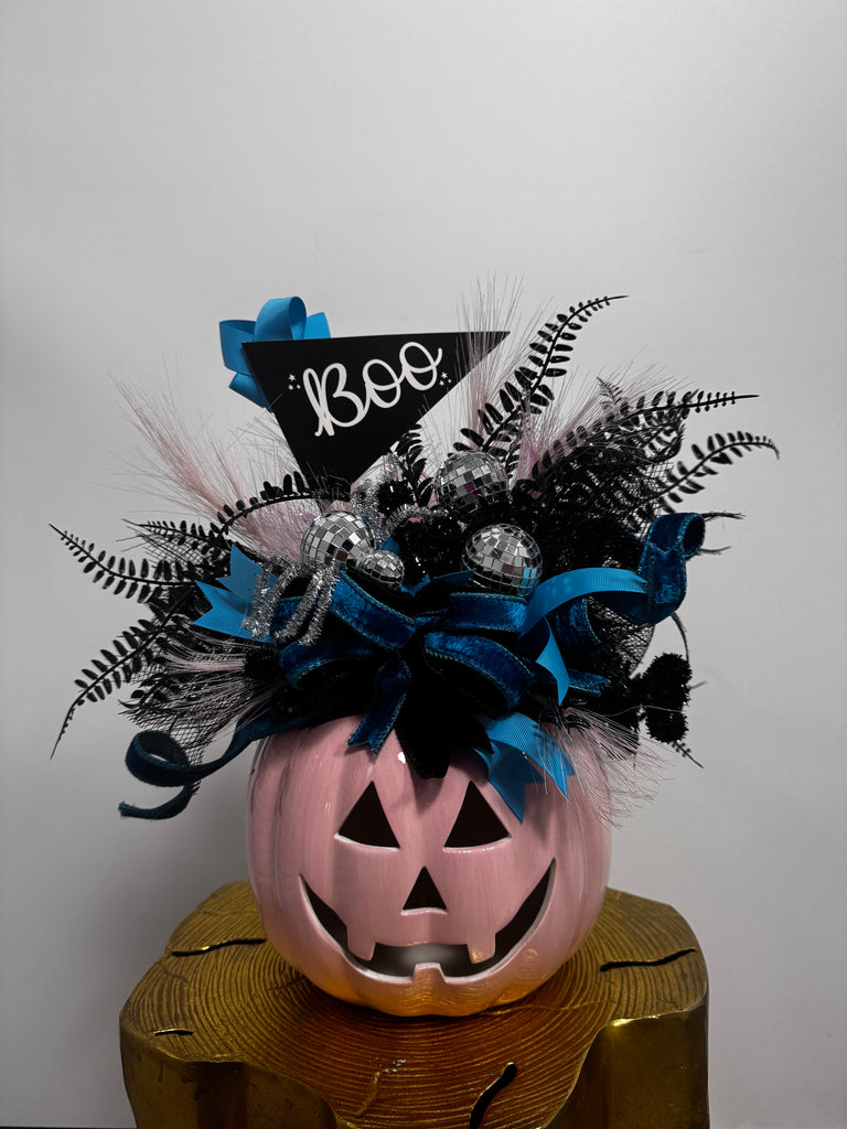 Halloween-themed decorative item with a jack-o'-lantern face and decorative elements on a white background