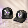 Two black Ryan Wayne embroidered hats on white marble